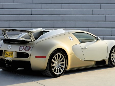 Beige Bugatti Veyron Next To A Gray Brick Wall