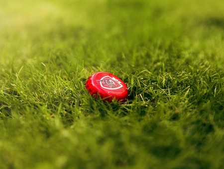 Red Bottle Cap On Green Grass In Tilt Shift Photography