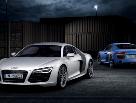Black And Gray Audi Sports Car In Front Of Blue Sports Car