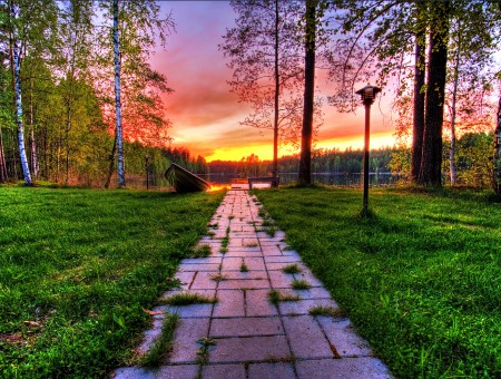 Paved Brick Pathway Leading To A Lake During Sunset