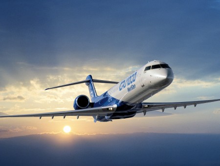 White And Blue Passenger Plane Flying Under Gray Sky