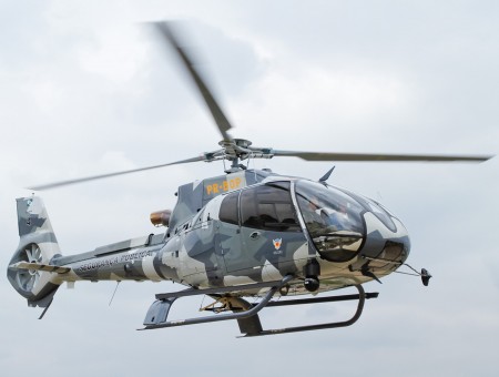 Green And Black Camouflage Helicopter Flying Under Cloudy Sky During Daytime