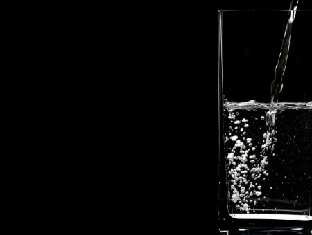 A glass with water on a black background