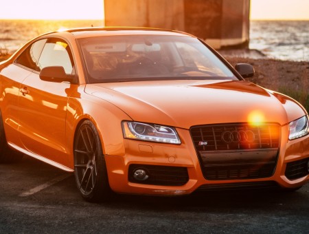 Orange sport Audi on coast