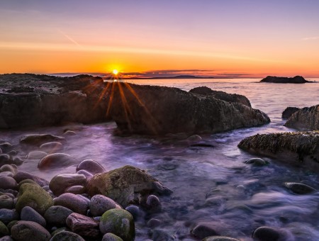 Sunset above rock coast