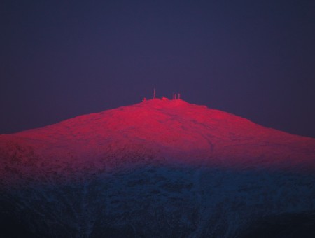 Snowy mountain above red light