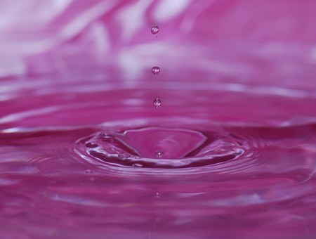 Drops fall in pink water